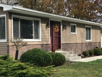 Tando Stacked Stone in Chestnut Hills, with Royal Siding in 4” Shiplap Walnut, White Trim & Windows